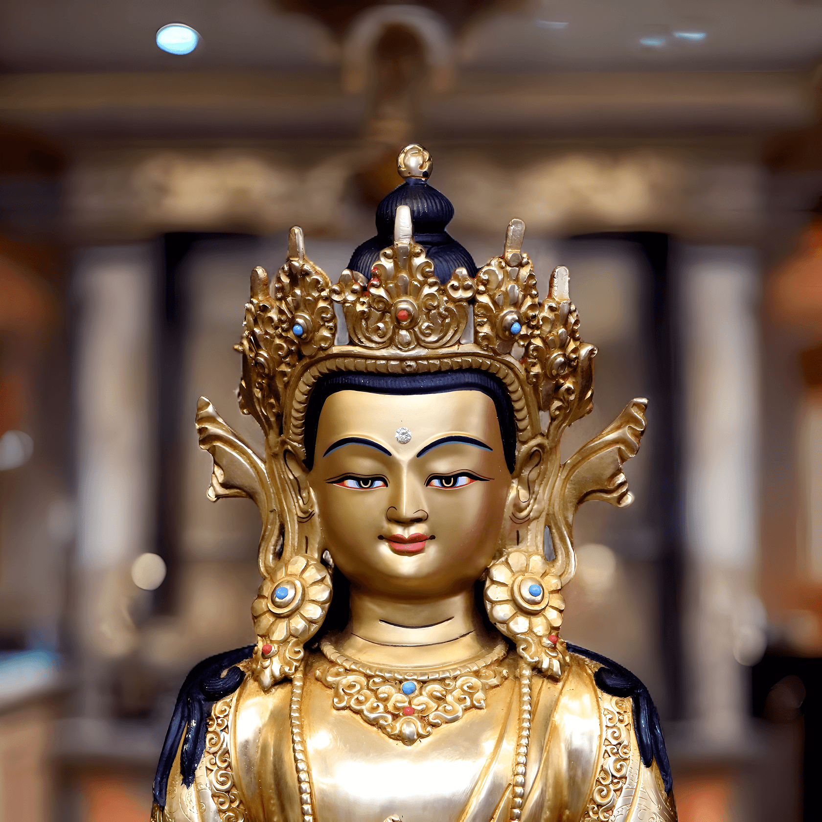 Nahaufnahme des Gesichts einer handbemalten Amitayus-Buddha-Statue (34 cm) mit Goldpigmenten.