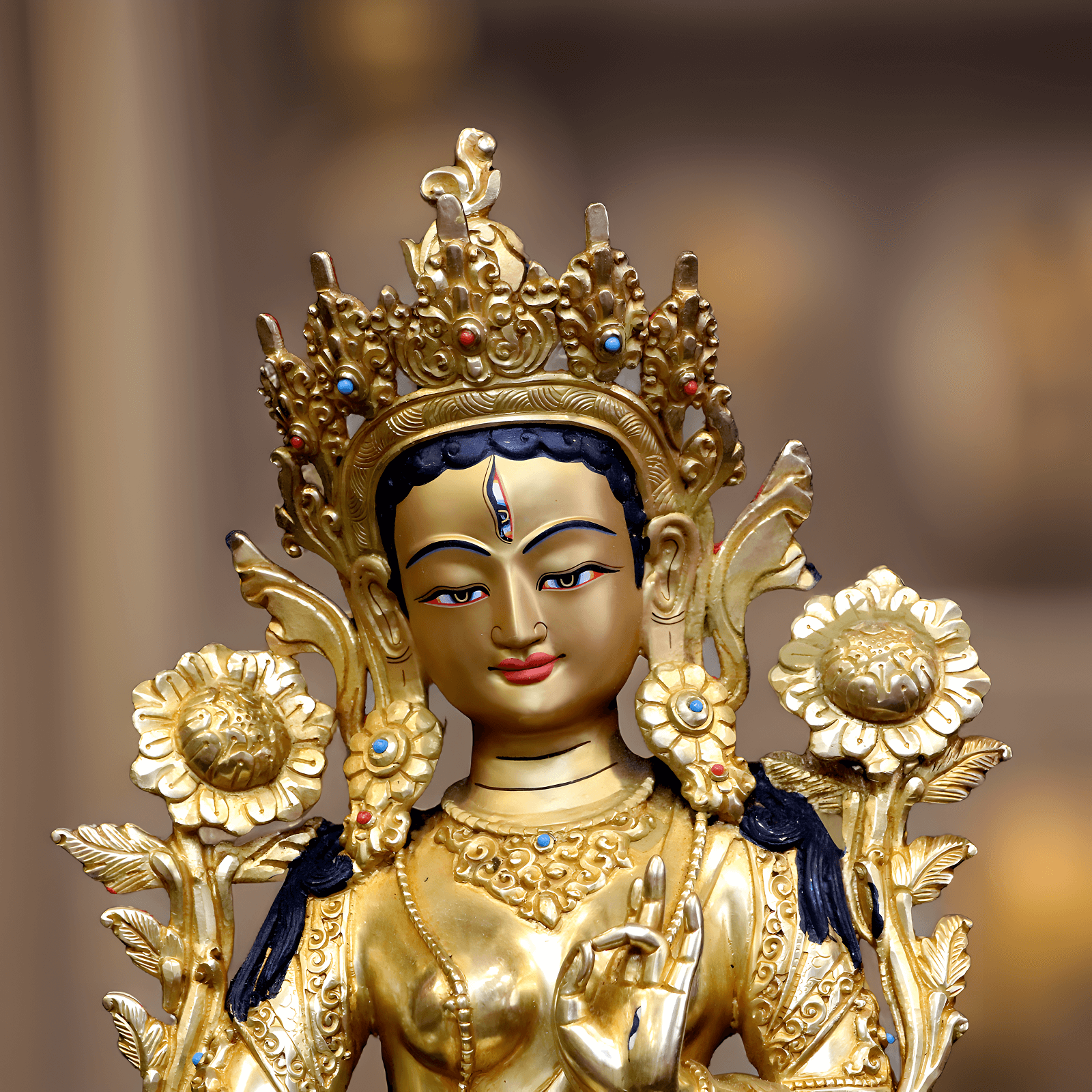 Nahaufnahme des Gesichts einer handbemalten Weiße Tara Statue (34 cm) mit Goldpigmenten.